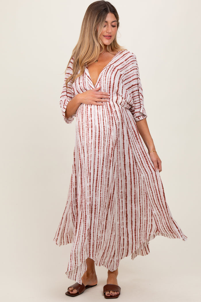 woman wearing a long white and red striped maternity dress and holding her baby bump