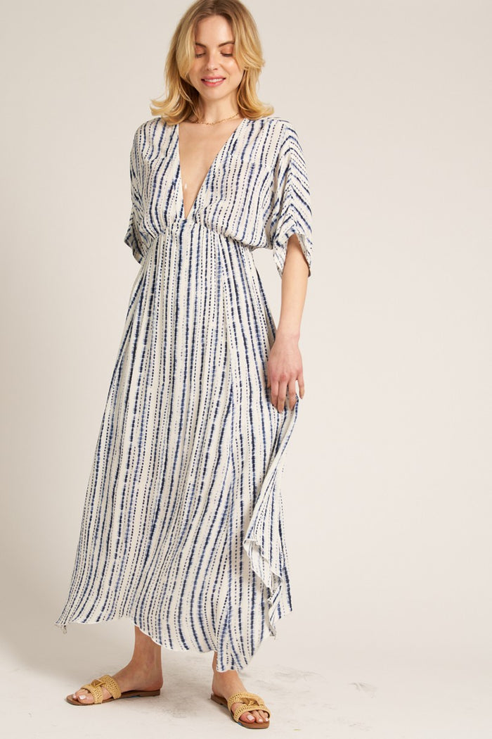 woman wearing a white and blue striped maxi dress with a deep v-neck and short kimono sleeves