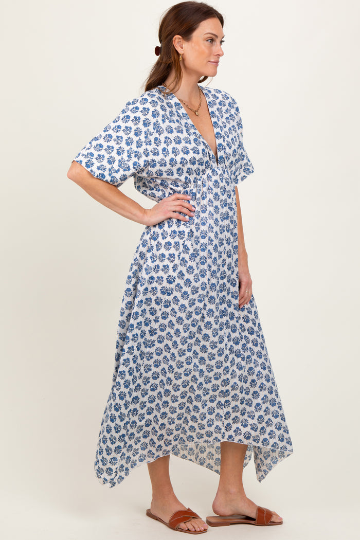 woman wearing a white and blue floral print maxi dress with short sleeves and a deep v-neckline