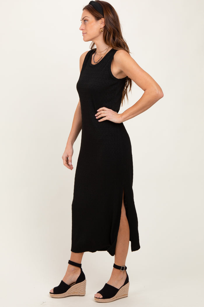woman wearing a black sleeveless maxi dress with side slits and wedge sandals