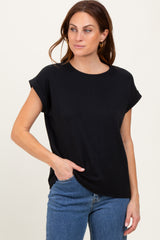 woman wearing a black short sleeve top with rolled cuffs and front pocket, paired with blue jeans