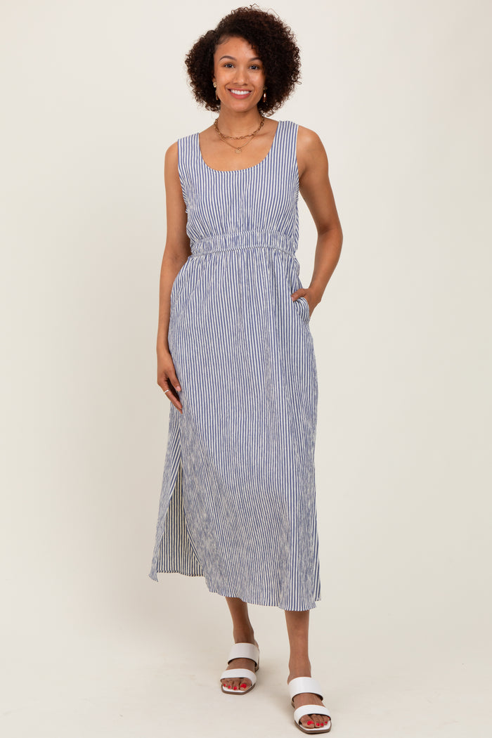 woman wearing a blue and white striped sleeveless maxi dress with an elastic waist and side pockets