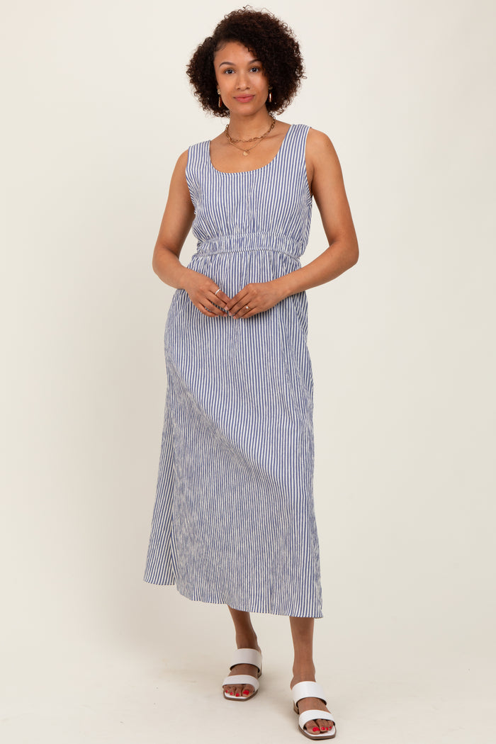 woman wearing a blue and white striped maxi dress with a cinched waist and a scoop neckline