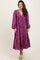 woman wearing a purple floral long sleeve maxi dress with a smocked waist and tiered skirt