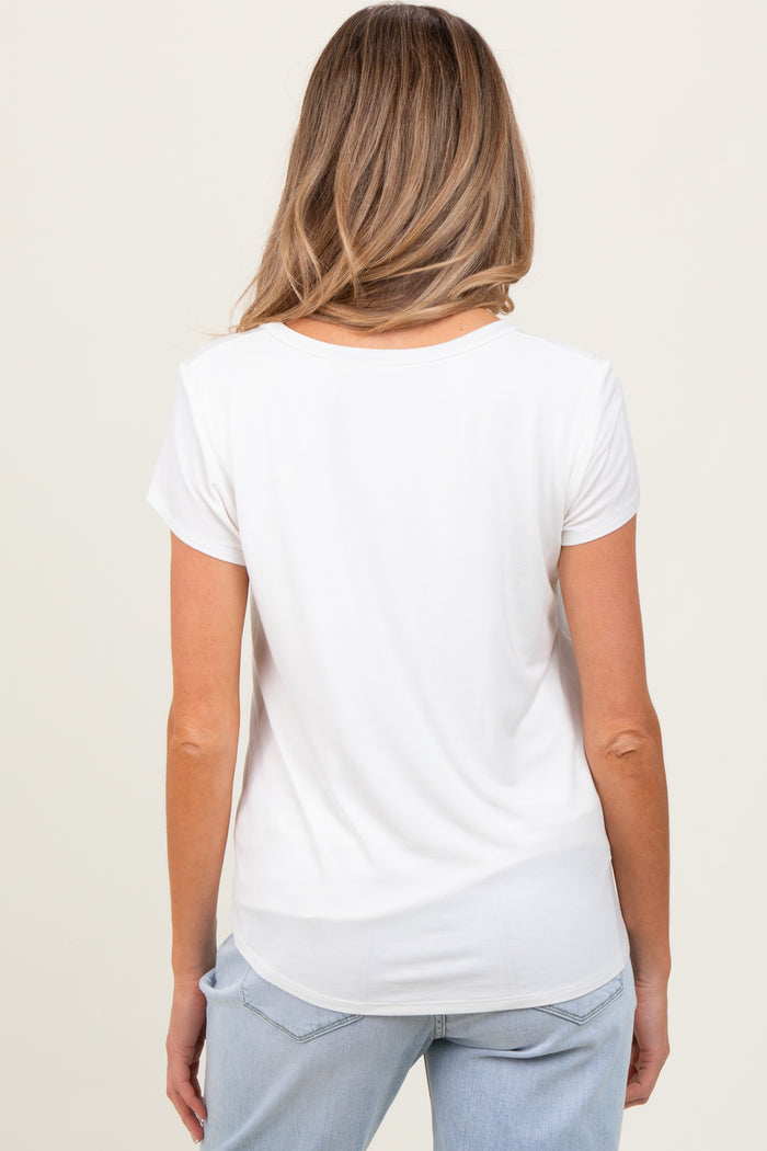 woman wearing a white short sleeve maternity top, viewed from the back, paired with light blue jeans