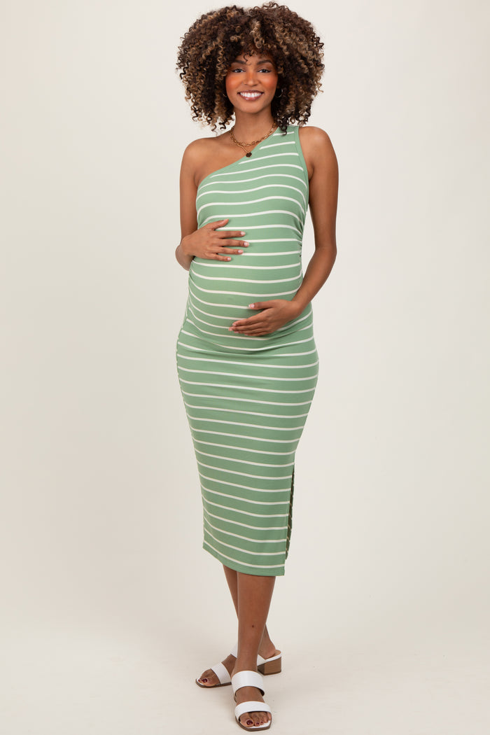 woman wearing a green and white striped one-shoulder maternity dress showcasing her baby bump