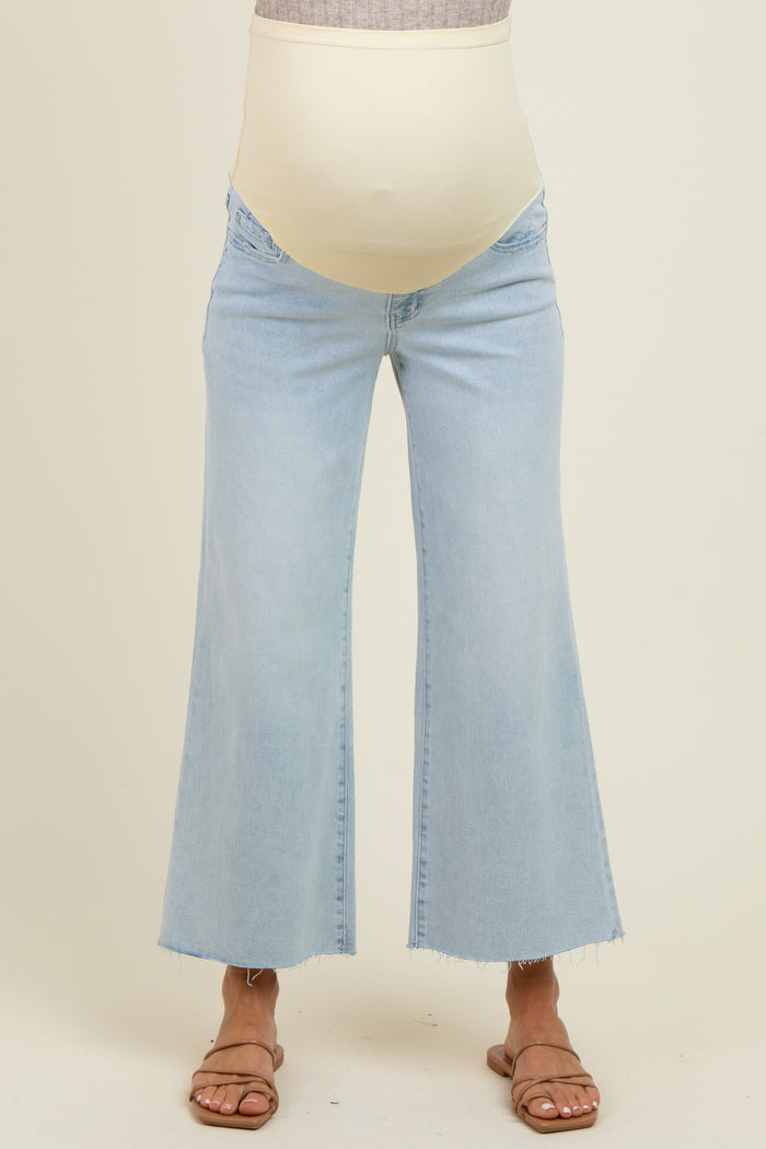 woman wearing light blue maternity wide-leg jeans with a stretchy beige belly panel