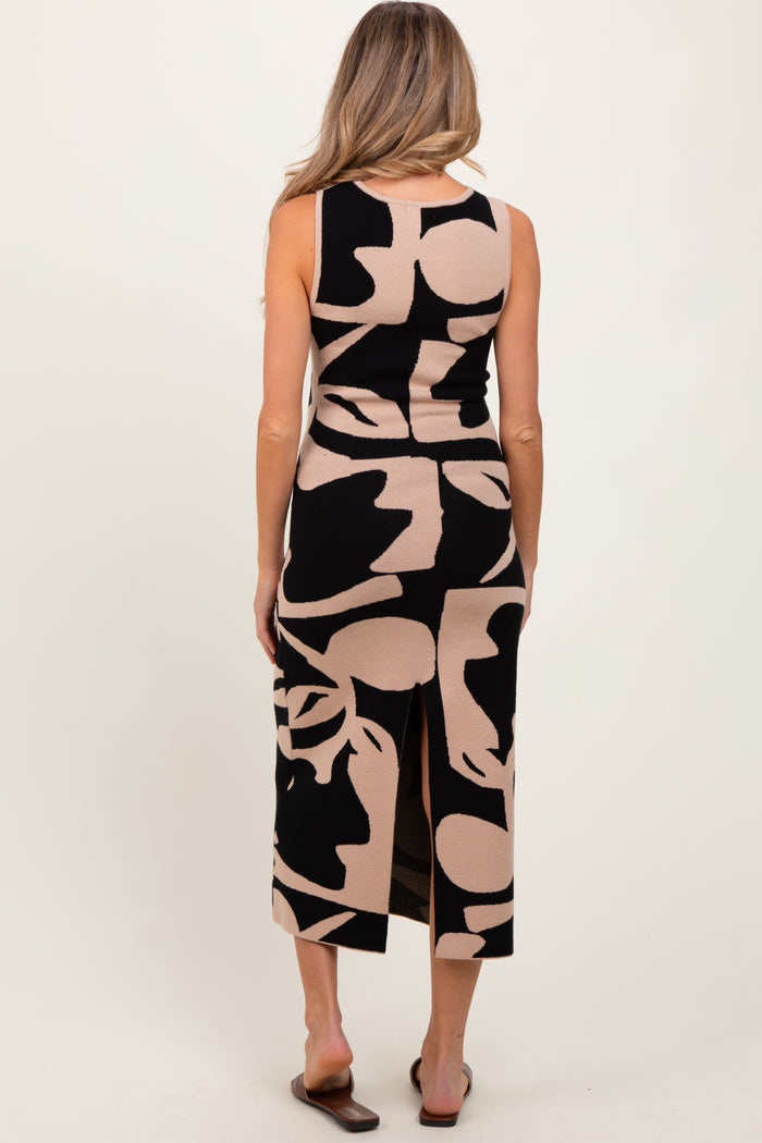 woman wearing a black and tan abstract patterned maternity dress with a back slit