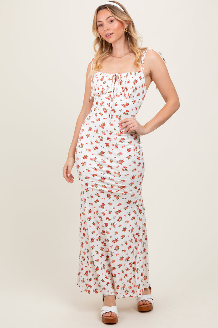 woman wearing a white floral maxi dress with adjustable straps and a fitted silhouette