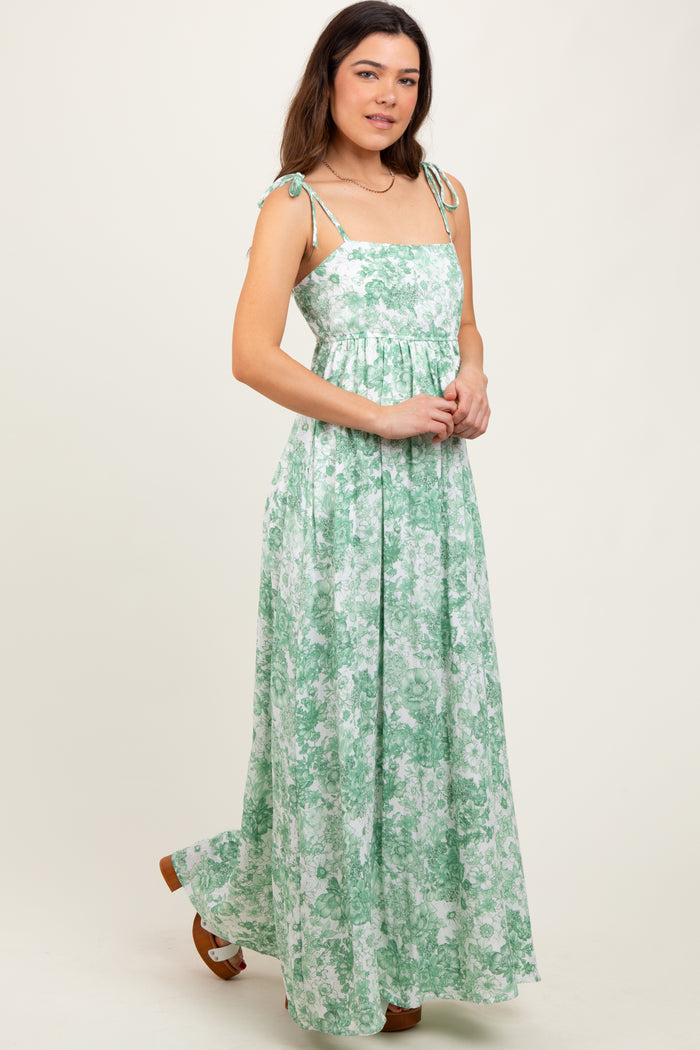 woman wearing a green floral maxi dress with adjustable straps and a tiered bodice