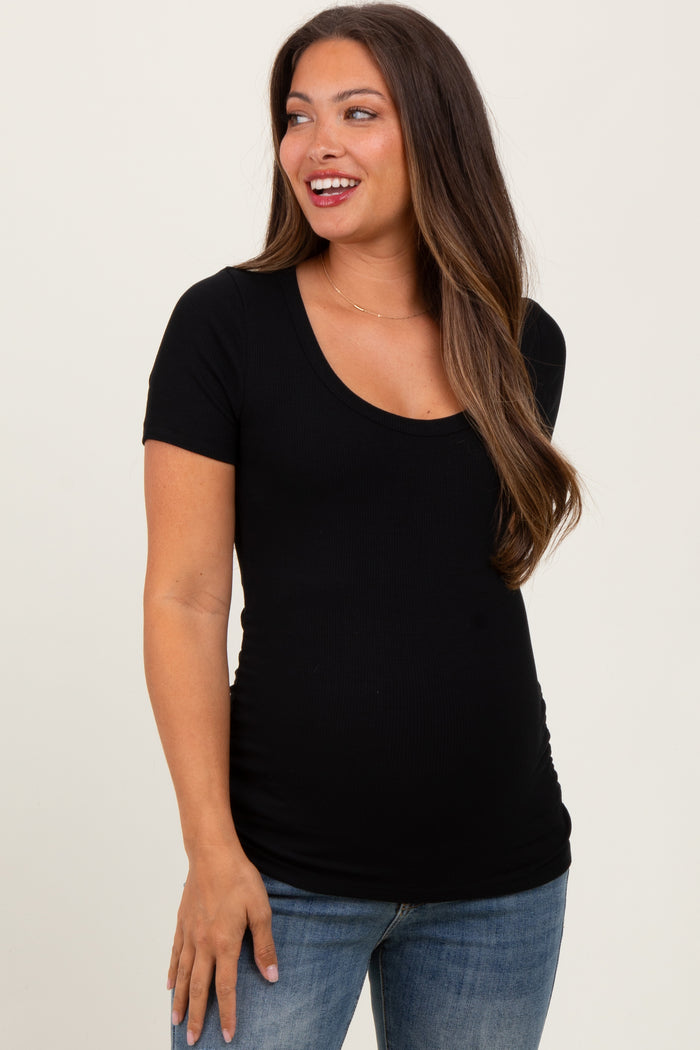 woman wearing a black short sleeve maternity top and showing her baby bump