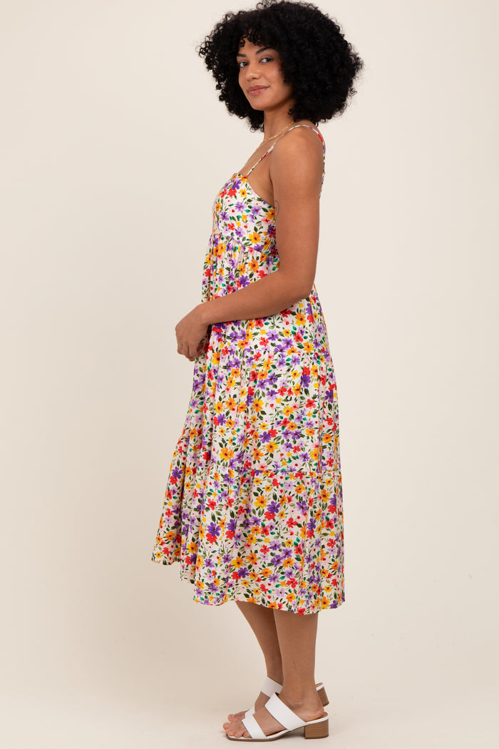 woman wearing a colorful floral print midi dress with spaghetti straps and a flared skirt