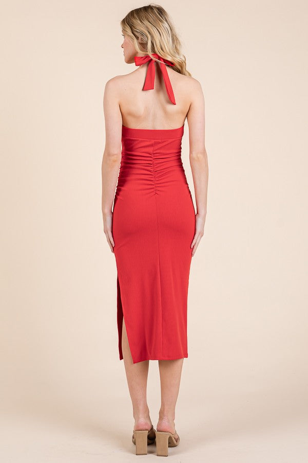 woman wearing a red strapless midi dress with ruching and a back tie detail, viewed from the back