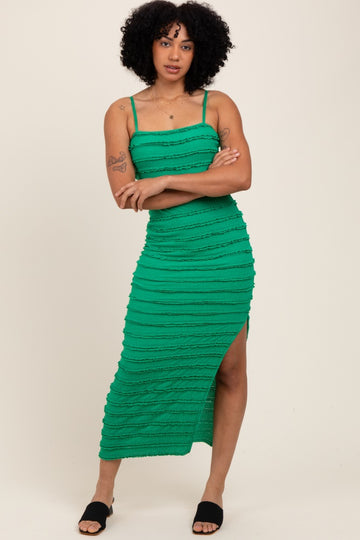 woman wearing a green striped midi dress with a thigh-high slit and spaghetti straps