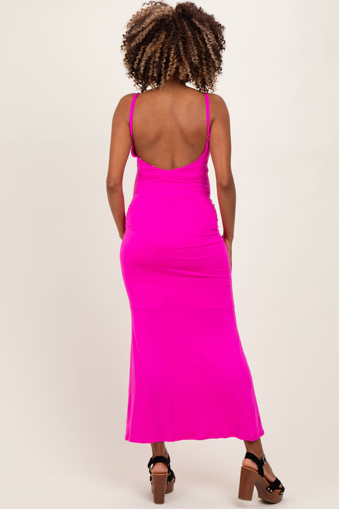 woman wearing a bright pink maternity maxi dress with a low back design