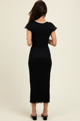 woman wearing a black midi dress with cap sleeves and a fitted silhouette, viewed from the back