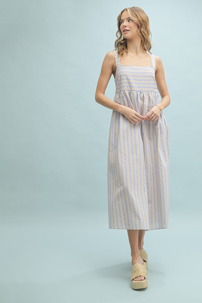 woman wearing a light blue and white striped maxi dress with square neckline and wide straps