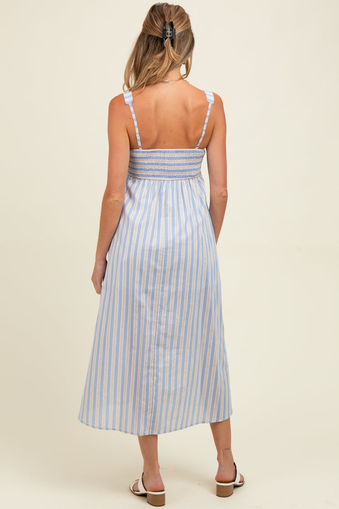 woman wearing a light blue and white striped maternity dress with a smocked back and adjustable straps