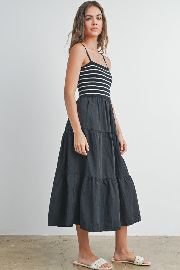 woman wearing a black and white striped tiered maxi dress with spaghetti straps and sandals