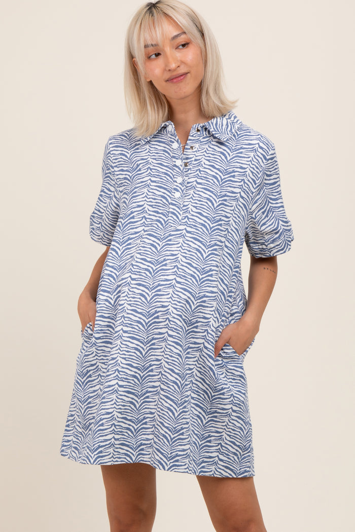 woman wearing a blue and white zebra print maternity dress with a collared neckline and pockets