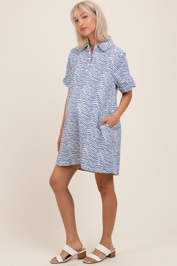 woman wearing a blue and white zebra print maternity dress with short sleeves and pockets, showing her baby bump