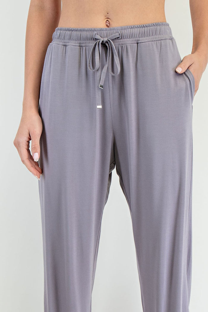 woman wearing light gray lounge pants with an elastic waistband and side pockets