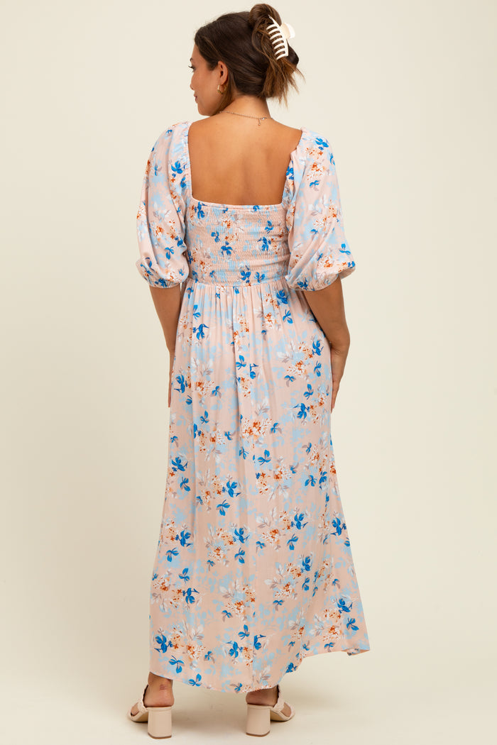 woman wearing a floral maternity maxi dress with puff sleeves and a smocked bodice, showing the back view