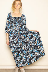 woman wearing a black floral maxi dress with a square neckline and puff sleeves
