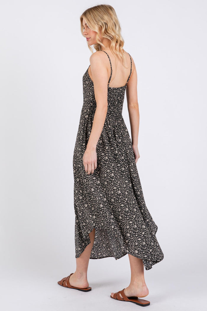 woman wearing a black floral maxi dress with spaghetti straps, seen from the back, styled with brown sandals