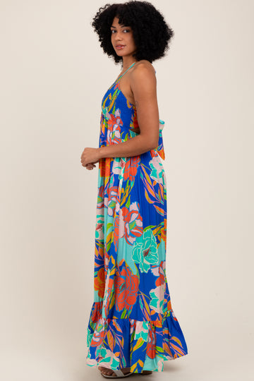 woman wearing a colorful floral maxi dress with a tiered hem and smocked bodice, posing sideways