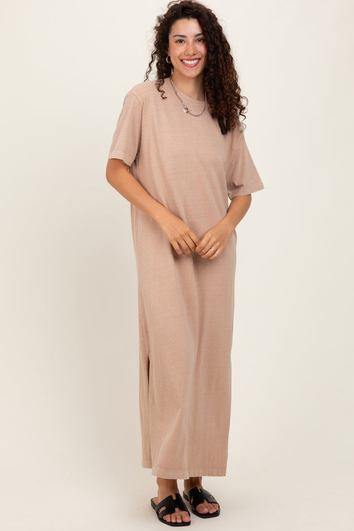 woman wearing a tan short sleeve maxi dress with a relaxed fit and side slits, standing and smiling