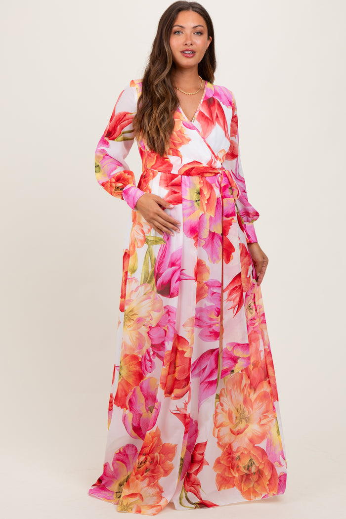 woman wearing a floral long sleeve maternity dress with a wrap design and a tie waist, showcasing her baby bump