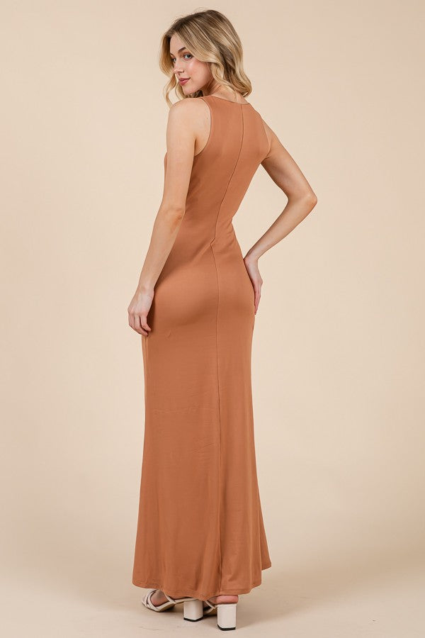woman wearing a sleeveless rust-colored maxi dress, showing a fitted silhouette and a side view of the back