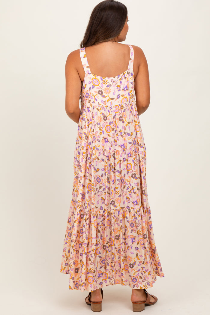 woman wearing a floral patterned maternity maxi dress with a tiered skirt, showing a baby bump from the back