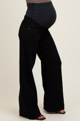 woman wearing black wide-leg maternity jeans with a supportive belly panel and a visible baby bump
