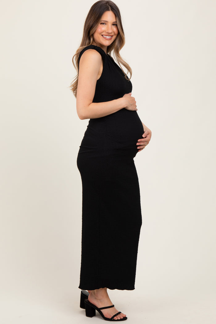 woman wearing a black ribbed maternity dress with a fitted silhouette and baby bump visible