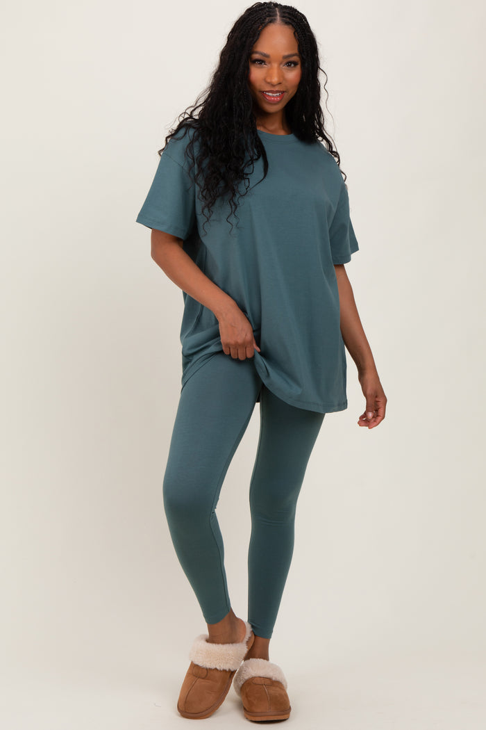 woman wearing a teal oversized t-shirt and matching leggings, styled with brown fuzzy slippers