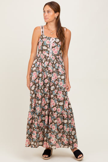 woman wearing a brown floral maxi dress with spaghetti straps and a tiered skirt