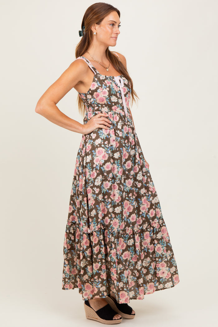 woman wearing a brown floral maxi dress with adjustable straps and a tiered skirt