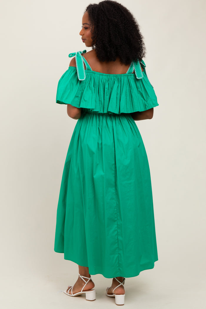 woman wearing a green off-the-shoulder maxi dress with ruffled detailing and ribbon straps, shown from the back