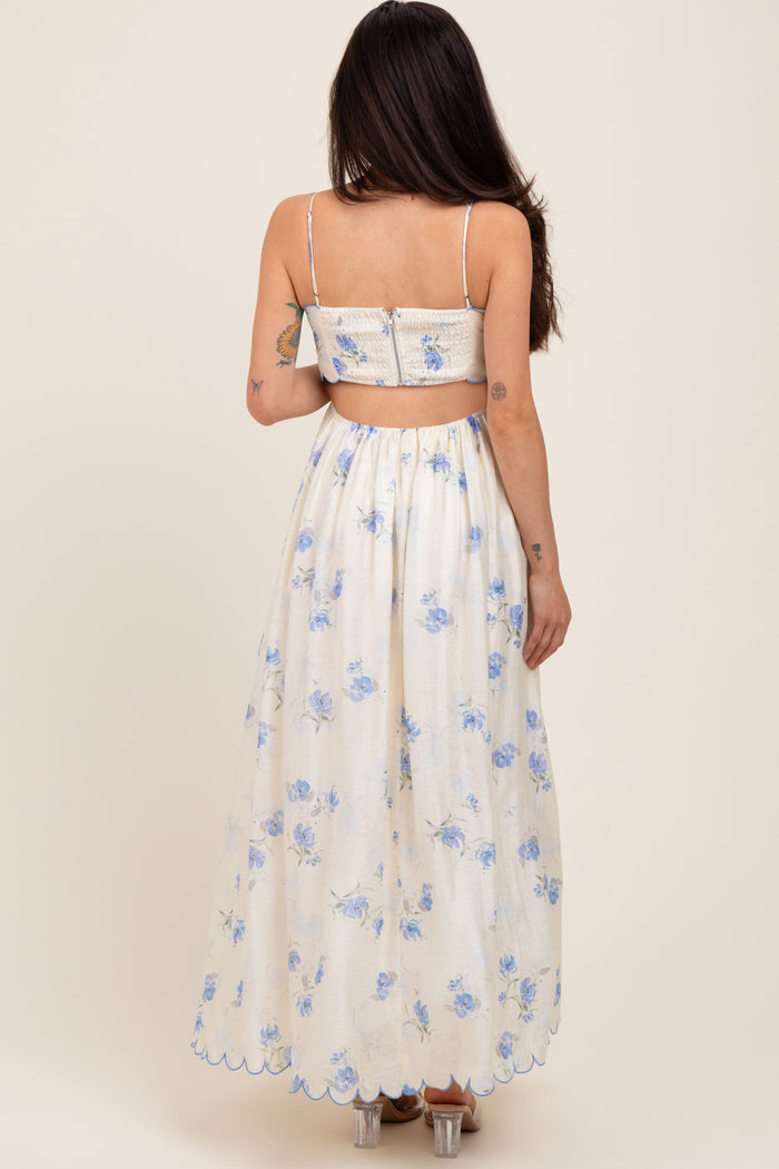 woman wearing a white floral maternity maxi dress with a backless design and blue flower patterns