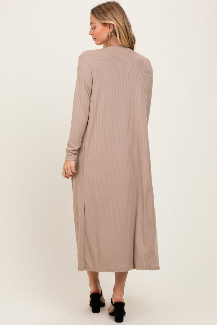 woman wearing a long beige ribbed cardigan with long sleeves and a relaxed fit, viewed from the back