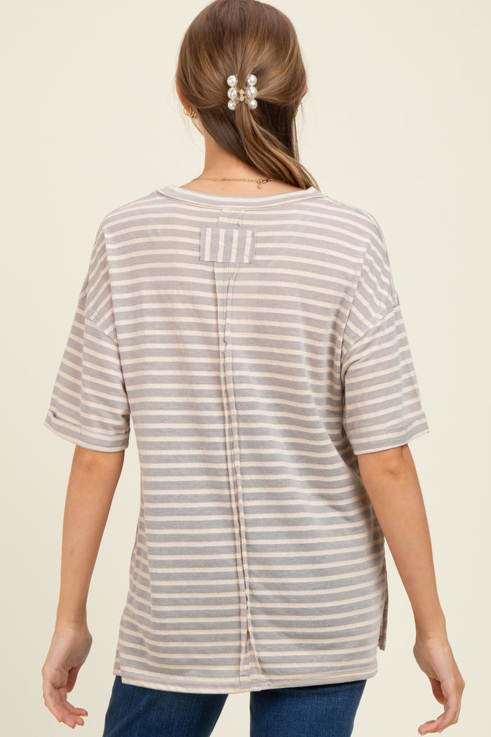 woman wearing a light gray and white striped maternity top with a back button detail and loose fit