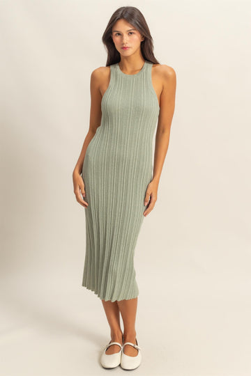 woman wearing a ribbed midi dress in sage green with a fitted silhouette and sleeveless design