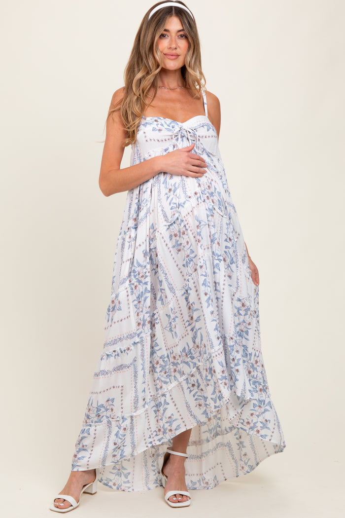 woman wearing a flowy white floral maternity maxi dress with adjustable straps and a baby bump visible