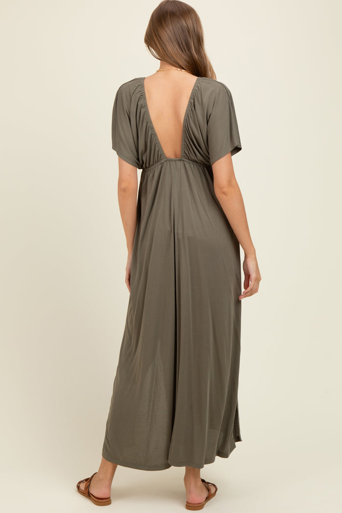 woman wearing a dark green maternity maxi dress with a deep V-back and short sleeves