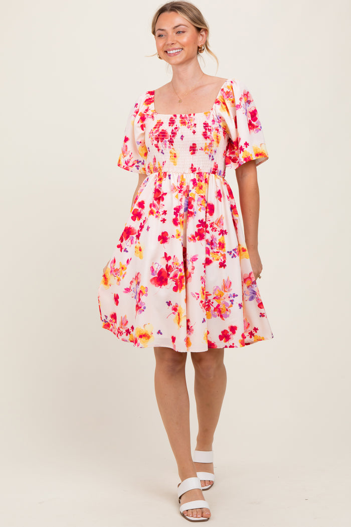 woman wearing a floral print short sleeve dress with a square neckline and a flowy skirt