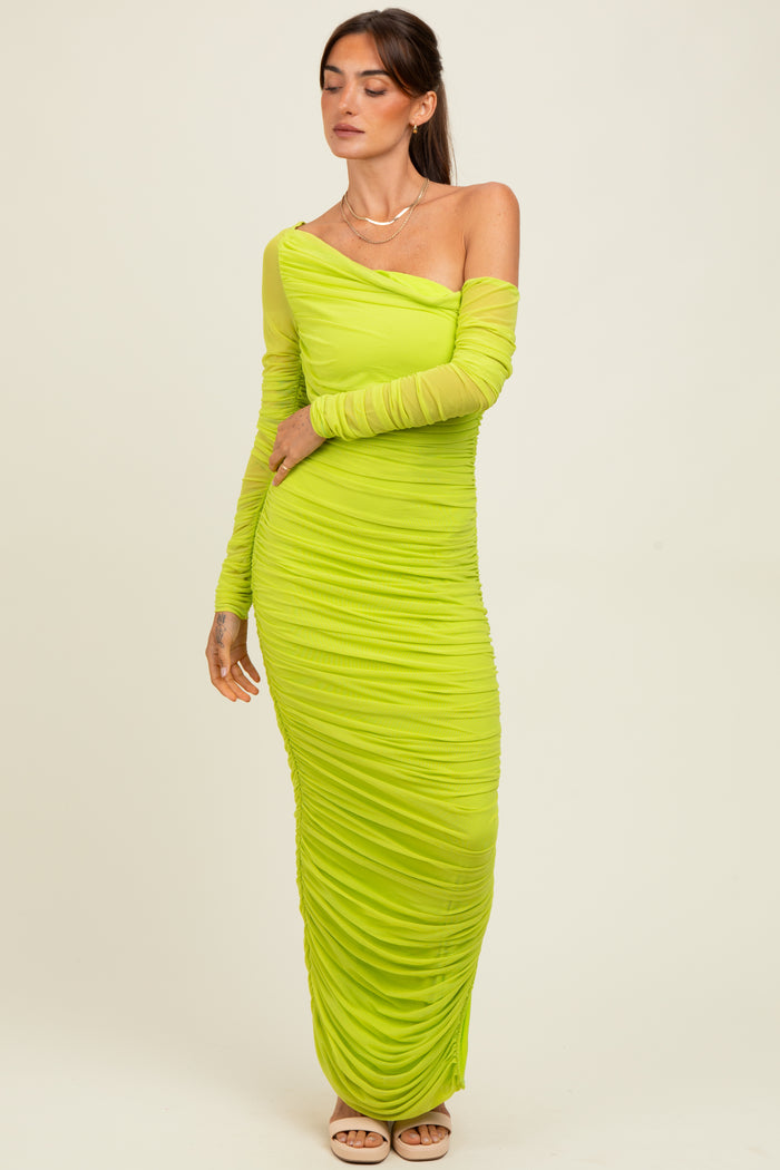 woman wearing a one-shoulder bright green ruched maxi dress with long sleeve detail