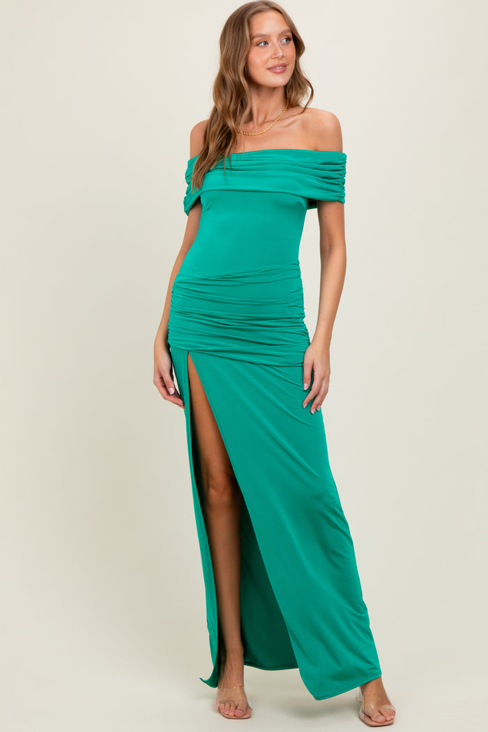 woman wearing a green off-the-shoulder maxi dress with ruched details and a thigh-high slit