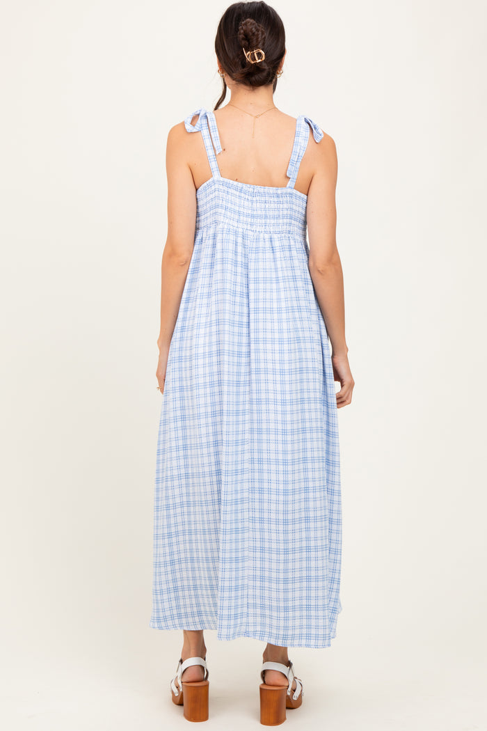 woman wearing a blue and white gingham maxi dress with tie shoulder straps and a smocked back